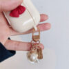 5d9008fe-e1f2-4d84-a8bc-9757a9c0fa02.jpg Beige Red Bow Shell Pendant Wireless Earphone Case